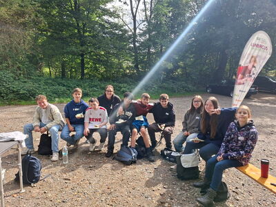 Eine Gruppe von Schülern sitzt im Halbkreis auf Bänken