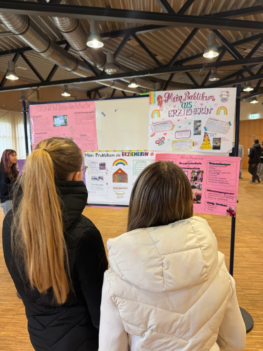 Zwei Schülerinnen begutachten eine Plakatwand