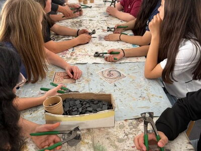 Die Klasse 6b sitzt gemeinsam an einem Tisch mit Mosaiksteinen