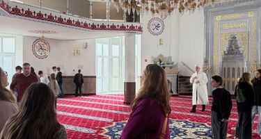 Mehrere Personen stehen zusammen in der Moschee