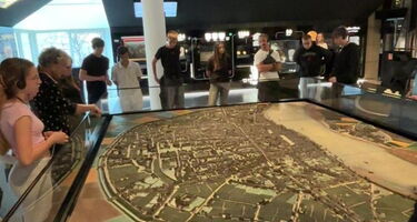 Schülergruppe steht um ein Ausstellungsstück