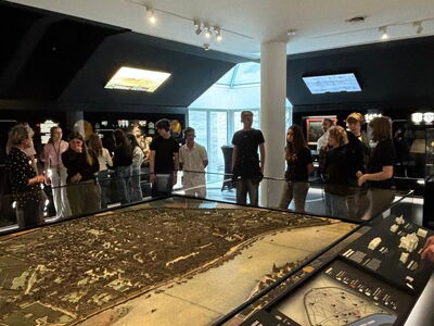 Schülergruppe steht um ein Ausstellungsstück
