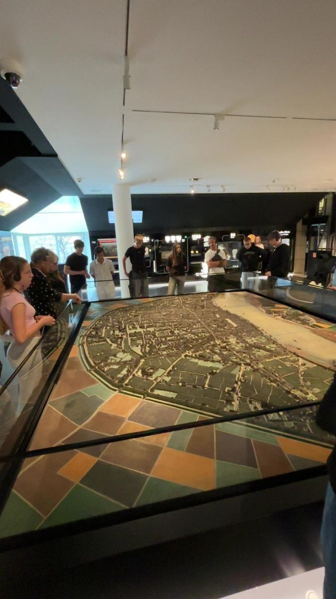 Schülergruppe steht um ein Ausstellungsstück