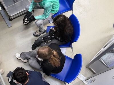 Schüler sitzen auf blauen Stühlen