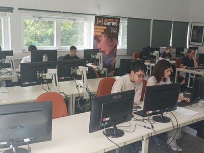 Schüler sitzen in einem Computerraum vor den PCs