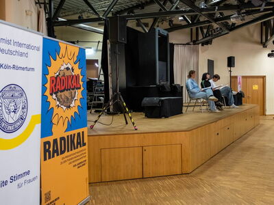 Mitglieder von Radikal – Comic on! sitzen auf einer Bühne