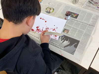 Ein Schüler hält eine Feder in der Hand