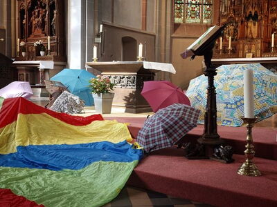 Aufgespannte Schirme ausgebreitet vor dem Altar