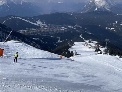 Blick auf die Skipiste mit Alpenpanorama im Hintergrund