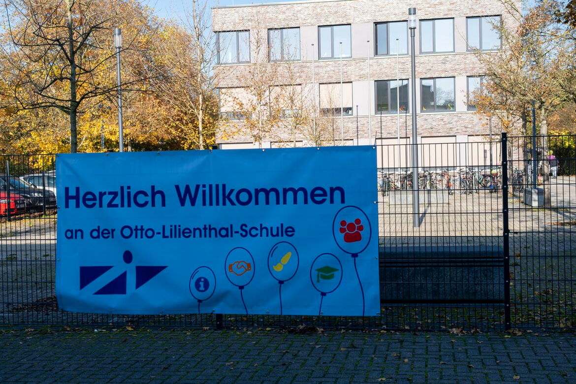 Am Zaun hängendes Plakat Herzlich willkommen