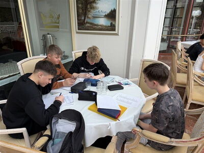 Schüler sitzen am Tisch und schreiben