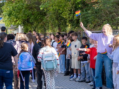 Schüler begrüßen mit Regenbogenfahnen die neuen Schüler