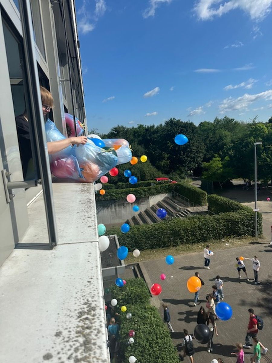 Bunte Luftballons fliegen aus dem Fenster