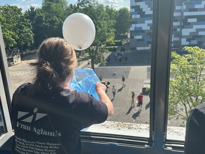 Luftballons werden aus dem Fenster geschüttet